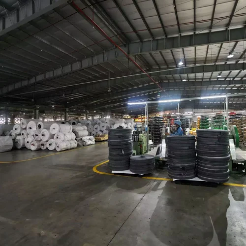 Rolls of woven fabric neatly stacked in warehouse
