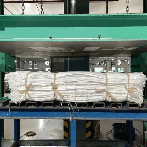 Woven bags being compressed by a hydraulic press before palletizing